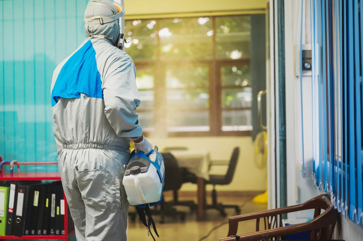 Professionnel projetant un produit fumigène dans un local de bureau